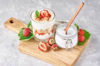 granola veya yoğurt cam çilek ile, taze çilek ve kavanoz şeker ile bir kesme tahtası, üst görünümü