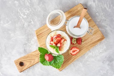 granola veya yoğurt cam çilek ile, taze çilek ve kavanoz şeker ile bir kesme tahtası, üst görünümü