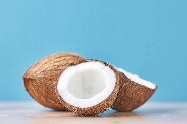 Tam Hindistan cevizi ve mavi bir arka plan üzerinde yarısı kırık, yakın