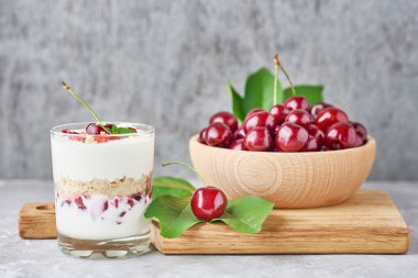 granola veya cam kiraz ile yoğurt, taze çilek ve kavanoz şeker ile bir kesme tahtası, üst görünümü