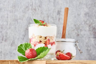 granola veya yoğurt cam çilek ile, taze çilek ve kavanoz şeker ile bir kesme tahtası üzerinde