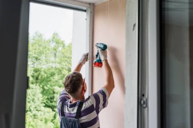 Tornavida kullanan adam süreci. İşçi pencere kurulumu yapar