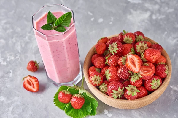 Χυμό φράουλα σε γυάλινο βάζο και φρέσκες φράουλες σε ξύλινο μπολ σε γκρίζο φόντο. Υγιεινό πρωινό — Φωτογραφία Αρχείου