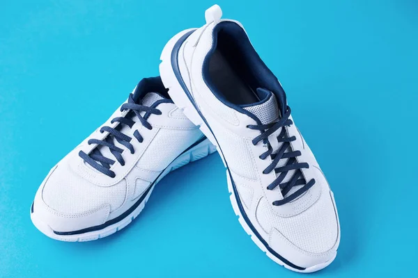 Mavi arka planda erkek beyaz spor ayakkabılar. Spor ayakkabı yakın çekim — Stok fotoğraf