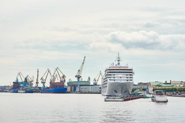 Tersanede vinç köprüsü ve limanda kargo gemileri var.