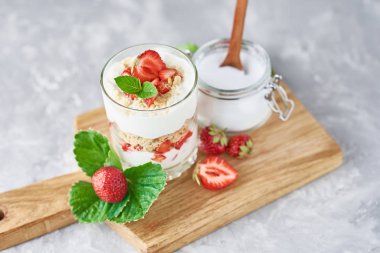 granola veya yoğurt cam çilek ve taze çilek bir kesme tahtası, üst görünümü. Sağlıklı kahvaltı