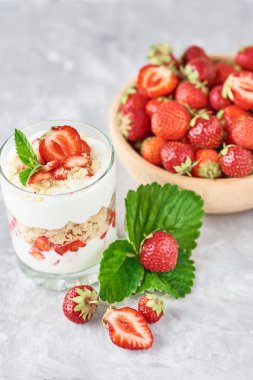 Çilek granola veya cam ve taze çilek ahşap bir kase içinde smoothie. Sağlıklı kahvaltı