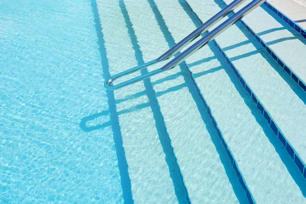 青いスイミングプールの水の背景、太陽の反射を持つ水面 — ストック写真