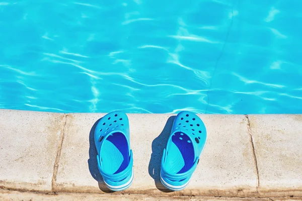Blue flip flops near a swimming pool, close up — Stock Photo, Image