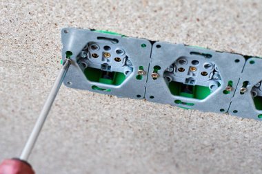 Adam el duvara tornavida ile elektrik prizi yüklemek