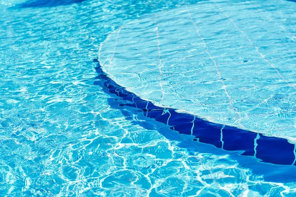 Mavi yüzme havuzunda su arka planı, güneş yansıması ile su yüzeyi