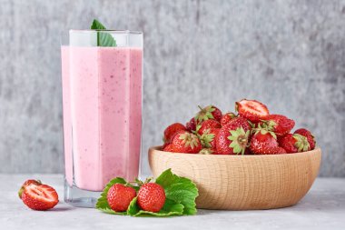 Cam kavanozda çilek smoothie ve odunsu taze çilek