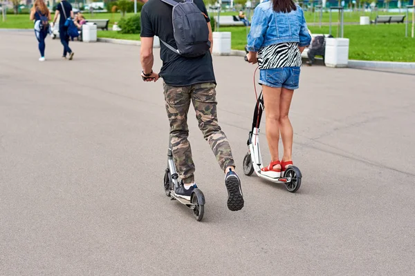 男女は、市内の電動スクーターに乗ります — ストック写真