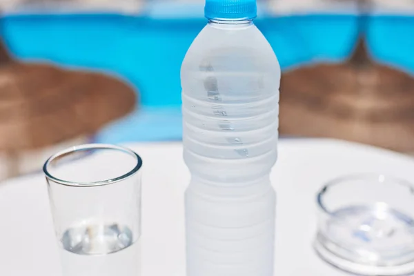 Glas en plastic fles met een water op witte tafel Temp zwembad achtergrond — Stockfoto