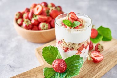 Çilek granola veya smoothie bir bardak ve ahşap kase taze çilek, üst görünümü. Sağlıklı kahvaltı