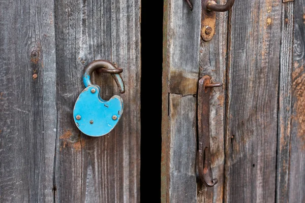Голубой старый ржавый замок на деревянной двери — стоковое фото