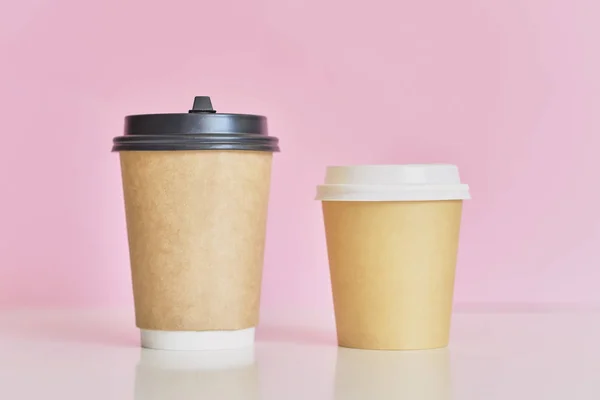 Két papír kávéscsészét a rózsaszín háttér. Kávé a szerelmes pár koncepció — Stock Fotó