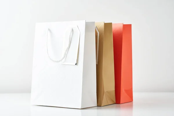 Trois sacs à provisions en papier coloré sur fond blanc — Photo