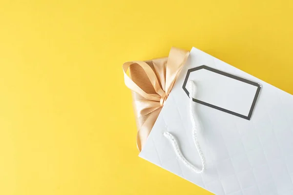 Mavi arka plan üzerinde hediye kutusu ile beyaz alışveriş çantası, üst görünümü — Stok fotoğraf