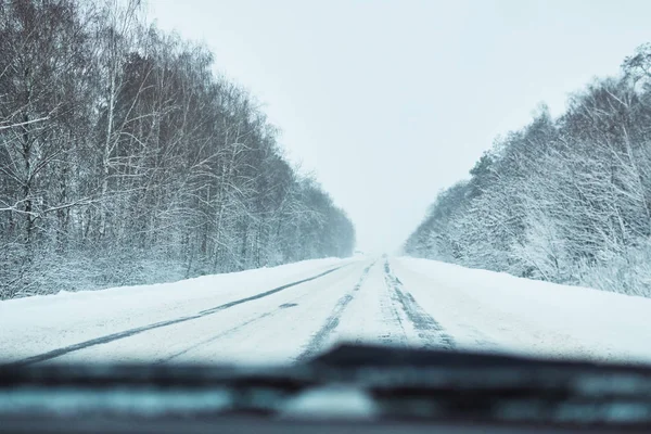 Widok z samochodu na śnieżnie zimowej drodze — Zdjęcie stockowe
