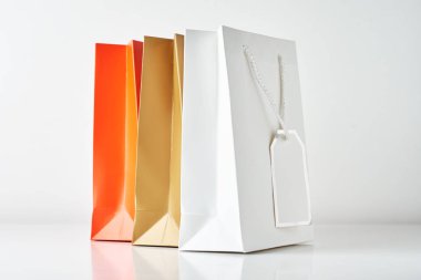 Beyaz arka plan üzerinde üç renkli kağıt alışveriş çantası