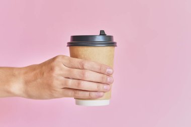 Kahve için kağıt bardak tutan kadın el pembe backg uzak almak