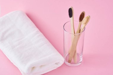 İki ahşap bambu çevre dostu cam ve beyaz diş fırçası.