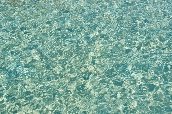 Hintergrund türkisfarbenes Wasser im Meer. Wasseroberfläche mit einer Sonne r — Stockfoto