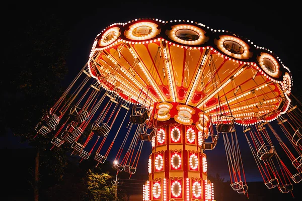 Φωτισμένη αλυσίδα ταλάντευσης καρουζέλ στο πάρκο διασκέδασης τη νύχτα — Φωτογραφία Αρχείου