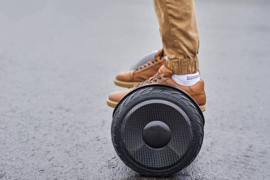 Asfalt yolda uçan kaykayı kullanan adama yaklaş. Ayaklar seçimde.