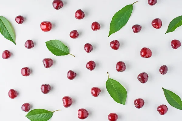 Bagas de cereja maduras e folhas de cereja em um fundo branco, topo — Fotografia de Stock