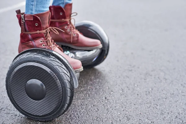 Close up of woman using hoverboard on asphalt road. Feet on elec — Stock Photo, Image