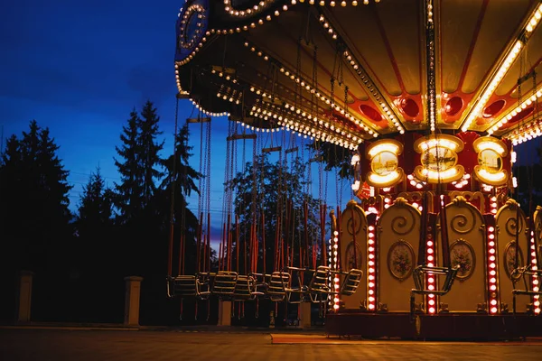 Carrusel Merry-go-round en el parque de atracciones en una ciudad nocturna —  Fotos de Stock