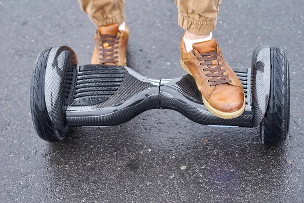 Primer plano del hombre usando hoverboard en el camino de asfalto. Pies en electr —  Fotos de Stock