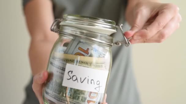 Kobieta Wkładająca Papierowy Banknot Szklanej Świnki Napisem Saving Koncepcja Oszczędności — Wideo stockowe