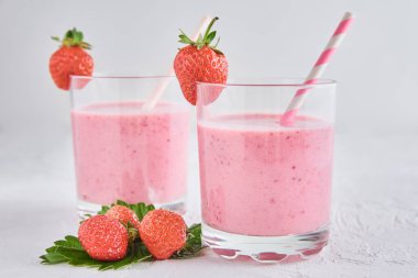 Bardakta çilekli milkshake ve beyaz arka planda taze böğürtlen.