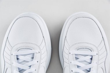 Beyaz arka planda beyaz erkek ayakkabısı, üst manzara. Moda tarzı spor ayakkabılar, yakın çekim.