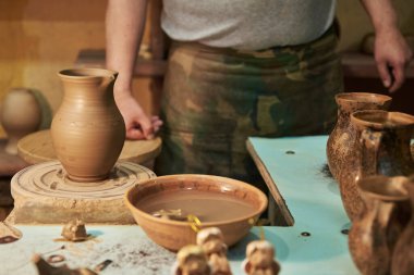 Atölyede çömlekçi çarkında kil tenceresi yapma süreci. Potter iş başında.