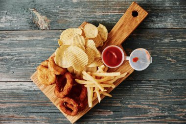 Sağlıksız ve abur cubur. Masada farklı türde fast food ve atıştırmalıklar var. Kapatın. Paket yemek.