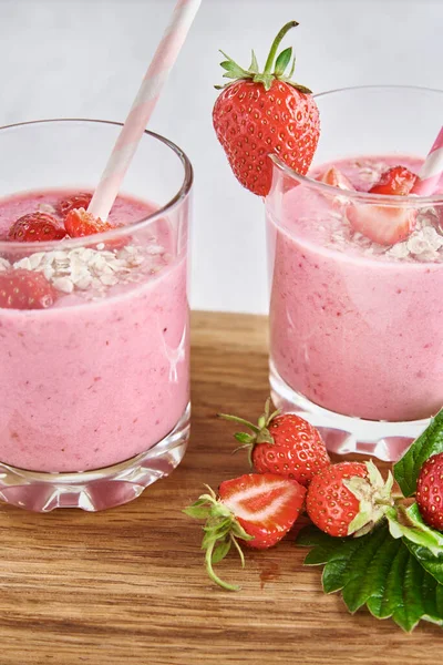 草莓牛奶在玻璃杯中摇曳 有稻草和白色背景的新鲜浆果 — 图库照片