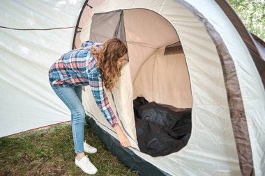 Ormanda kamp çadırı kuran kadın.