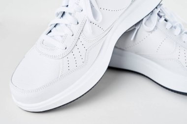 Beyaz arka planda bir çift beyaz erkek spor ayakkabı. Moda tarzı spor ayakkabılar, yakın çekim.