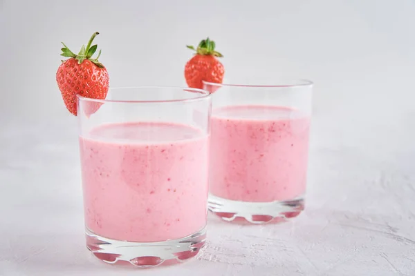 两杯草莓奶昔和白底新鲜浆果 — 图库照片