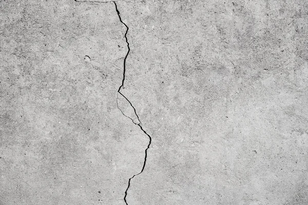 Damaged wall. Gray background with a crack