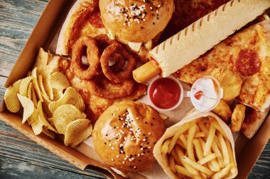 Sağlıksız ve abur cubur. Masada farklı türde fast food var. Kapatın.