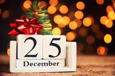 Noel konsepti. Tahta bloklar takvimi 25 Aralık 'ta bulanık bokeh ışık arkaplanına karşı.