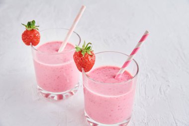 Bardakta çilekli milkshake ve beyaz arka planda taze böğürtlen.