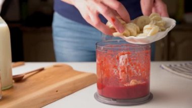 Kadın muzlu ve sütlü smoothie yapıyor.