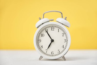 Sarı arka planda, kopyalama alanı olan beyaz alarm saati. Zaman kavramı