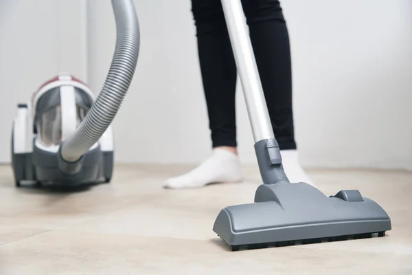 Woman using vacuum cleaner at the floor